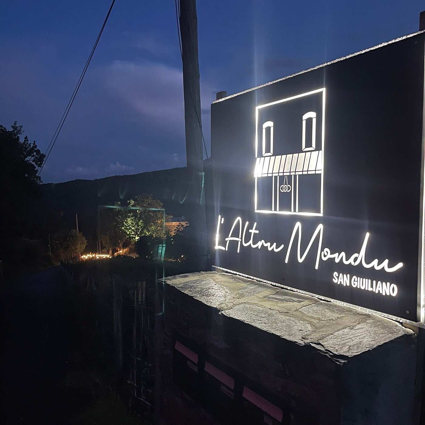 L'enseigne de l'Altru Mondu, le soir venu