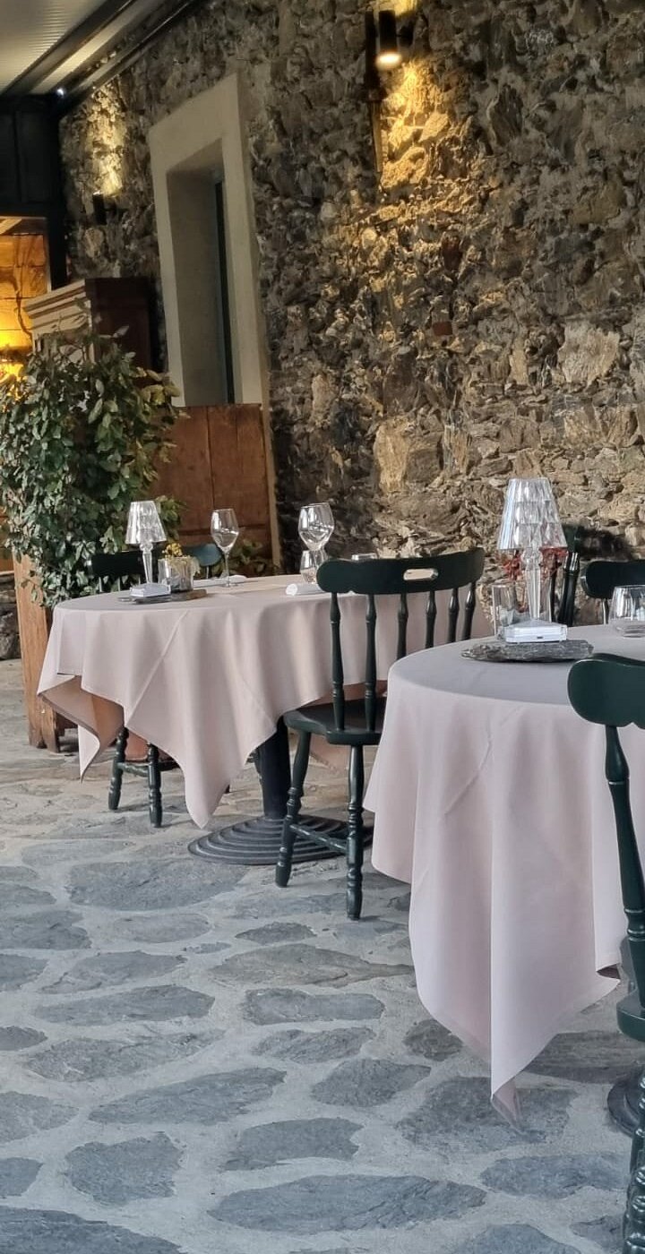 La salle, murs en pierre et tables nappées